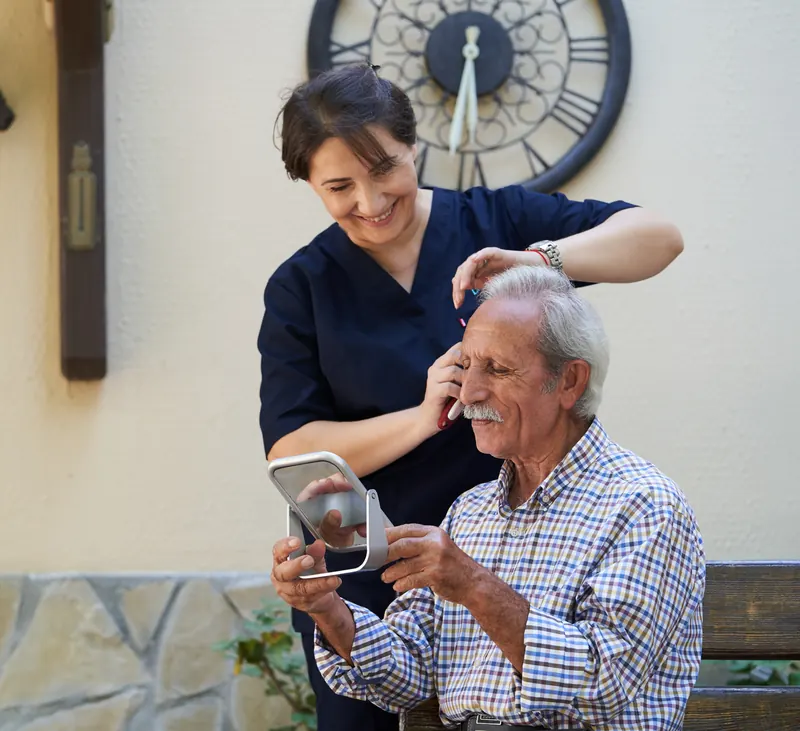 A carer helping an older man with his hair